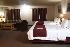 a hotel room with a bed, desk, chair and a lamp at Woodside Dells Hotel & Suites in Wisconsin Dells