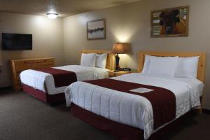 a hotel room with two beds and two lamps at Woodside Dells Hotel & Suites in Wisconsin Dells