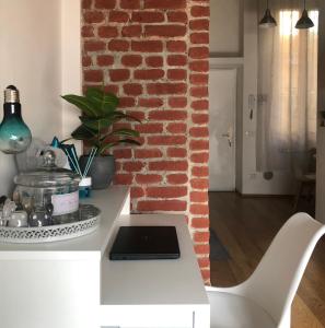 a kitchen with a white counter and a brick wall at Lovely Loft Isola/Garibaldi in Milan