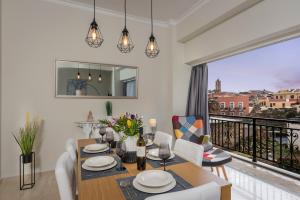 een eetkamer met een tafel en een balkon bij Old Harbor Apartment Luxury Living Chania in Chania