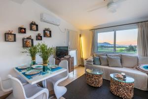 a living room with a couch and a table at Akamas Sunset Bohemian Chic Apartment by ONE VILLAS in Polis Chrysochous