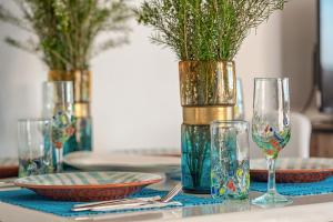 a table with plates and glasses and vases on it at Akamas Sunset Bohemian Chic Apartment by ONE VILLAS in Polis Chrysochous