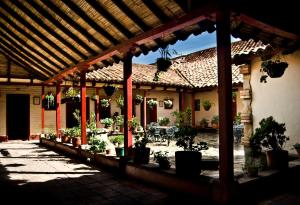 an outdoor patio with potted plants and a pergola at Hotel Cacique Real in Zipaquirá
