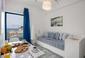 una camera bianca con un letto e un tavolo con cibo sopra di Seagull Hotel and Apartments ad Agia Marina Nea Kydonias