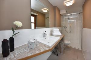 een badkamer met een wastafel, een toilet en een spiegel bij Landhaus Torghele in Schruns