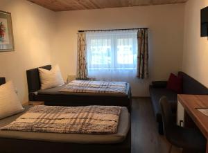 2 camas en una habitación con ventana en Ferienwohnungen Tischlerhof, en Ebbs