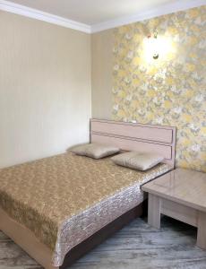 ノヴォシビルスクにあるFashionable and stylish apartments Gorskiyのベッドルーム(ベッド1台、テーブル付)