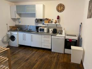 una cucina con elettrodomestici bianchi e pavimenti in legno di Le Chellois appartement La Bresse a La Bresse