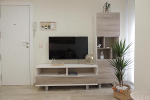 una sala de estar con TV en un centro de entretenimiento blanco en Apartamento la Unión II , calidad y comodidad, en Castellón de la Plana