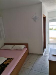 een kleine slaapkamer met een bed en een raam bij Danijela in Nin