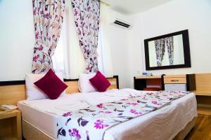 a bedroom with a large bed with pink pillows at Hotel Hermes in Kaş