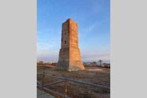 a tall brick tower in a field with a fence at Ocean view, Luxury & Relax Dunas de Artola in Marbella