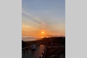 two people walking down a stairway to the beach at sunset at Ocean view, Luxury & Relax Dunas de Artola in Marbella