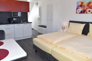 a bedroom with a large bed and a kitchen at Apartment Aurachtal Münchaurach in Falkendorf