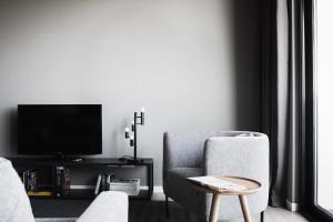 a living room with a chair and a tv at Dreams Hotel Città Studi in Milan