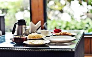 a table with plates of food on a table at Sood's Himalayan Vista in Kalimpong
