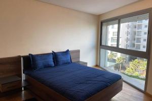 a bedroom with a bed with blue sheets and a window at Brand new, Stylish & Well located Apartment in Casa-Marina 12 in Casablanca