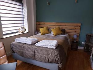 um quarto com uma cama com dois travesseiros em Le cocon em La-Roche-en-Ardenne