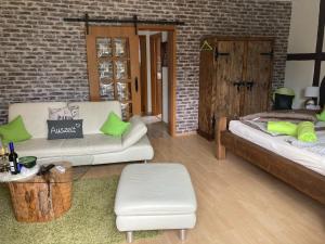 a living room with two white couches and a brick wall at Ferienwohnung Puschel in Salzhemmendorf