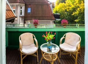 2 sedie e un tavolo in vetro con fiori sul balcone di Apartament Winieckiego a Sopot