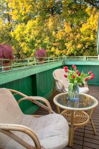 a patio with chairs and a table with a vase of flowers at Apartament Winieckiego in Sopot