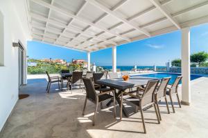 a patio with a table and chairs and a view of the ocean at Top Renovated Villa with Sea-Views and Pool in Fuengirola