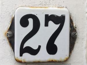 a black and white number sign on a wall at De Maecht van Mechelen in Zierikzee