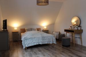 a bedroom with a bed and a desk and two lamps at Ferienhaus Am Stadtpark in Bad Harzburg