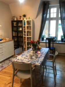 a dining room with a table with flowers on it at Apartament Winieckiego in Sopot