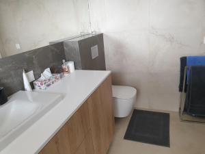 a bathroom with a white sink and a toilet at Apartament Kapitana Sea Wave in Darłówko