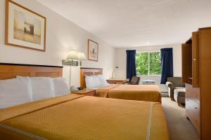 Pokój hotelowy z 2 łóżkami i biurkiem w obiekcie Travelodge by Wyndham Port of Tacoma WA w mieście Fife