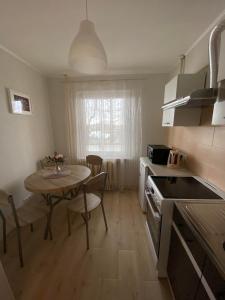 a kitchen with a table and a small kitchen with a table and chairs at Apes ielas apartaments in Alūksne