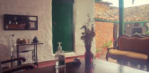 a vase with flowers on a table with a chair at Mi Ranchito, Centro in Barichara