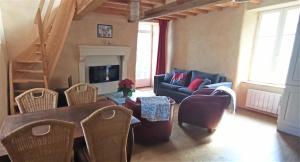 a living room with a couch and a table and chairs at Gîte de charme Floréales Les Myosotis in Asnelles