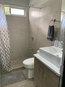 W łazience znajduje się umywalka, toaleta i prysznic. w obiekcie Apartamentos Ganesha Jacó w mieście Jacó