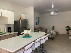 eine Küche und ein Wohnzimmer mit einem Tisch und Stühlen in der Unterkunft Apartamentos Ganesha Jacó in Jacó