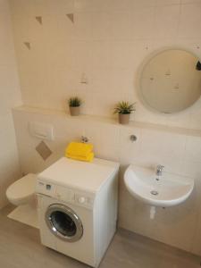 a bathroom with a washing machine and a sink at Schwarzwaldmarie Ferienwohnung in Löffingen