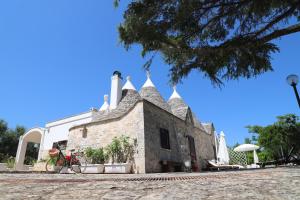 a building with a roof with a bike in front of it at Trulli Anna in Cisternino