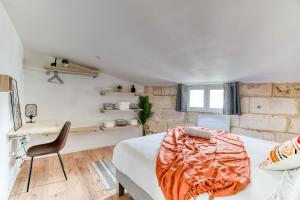 Un dormitorio con una cama, un escritorio y una silla. en Cosy Up - Vieux Port - Hyper Centre, en La Rochelle