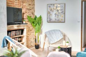 sala de estar con silla de mimbre y TV en Cosy Up - Vieux Port - Hyper Centre, en La Rochelle