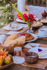 uma mesa de madeira com pratos de comida sobre ela em Pousada Vila das Águas em Caraíva mais 95 fotografias