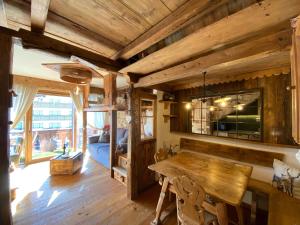 Calore di una Casa di Montagna في كامبيتيلو دي فاسا: غرفة خشبية مع طاولة وسرير