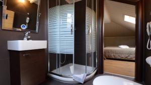 a bathroom with a shower with a sink and a toilet at Atrium Hotel Thassos in Potos