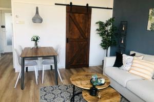 una sala de estar con un sofá y una mesa en Green Happiness With Private Parking, en Zandvoort