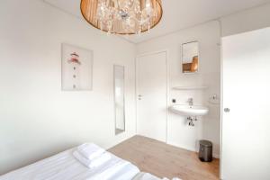 - une salle de bains blanche avec un lit et un lavabo dans l'établissement Sea Star Stay with Private Parking!, à Zandvoort