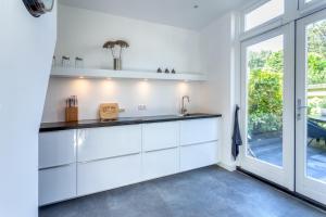 ザントフォールトにあるCasa Vos Family Homeの白いキャビネットと大きな窓のあるキッチン +28枚の写真