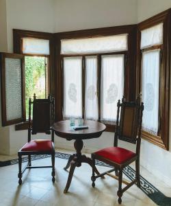 uma mesa e duas cadeiras num quarto com janelas em Posada Los Angelos em Ramallo