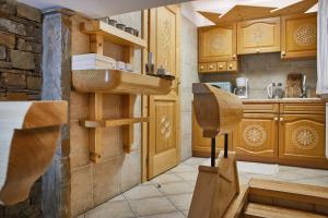 a kitchen with wooden cabinets and a sink at Witkówka WILD Luxury Apartments - Sauna & SPA x Adults Only in Witów