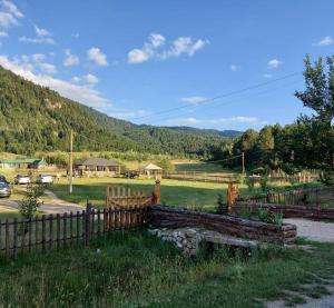 una recinzione di legno in un campo con una montagna di Camping Farm Shelegur a Leskovik