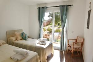 a bedroom with two beds and a large window at Villa Bella in Es Mercadal +30 photos